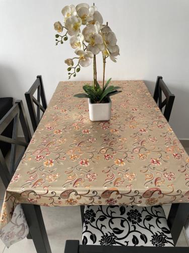 a table with a table cloth with a potted plant on it at Has Hills Residence - 2 BEDROOMS CONDO with WiFi in Kajang