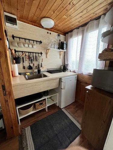 a small kitchen with a sink and a counter at MANDULÁS KABIN a kisház dézsával és kilátással a Balatonra in Balatongyörök