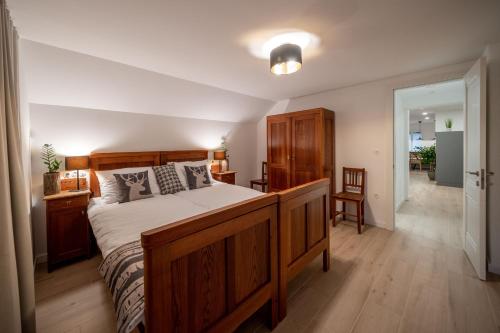 a bedroom with a large wooden bed and a hallway at House Leska in Kranjska Gora