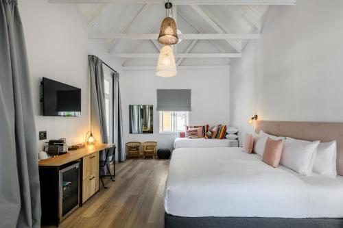 una camera d'albergo con due letti e una televisione di iGadi House Boutique Hotel a Città del Capo