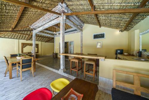 een woonkamer met een tafel en stoelen en een keuken bij Villa Matahari - Cute 1 bdr villa with private pool in Gili Meno