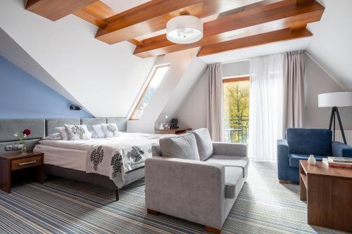 - une chambre avec un lit, un canapé et une chaise dans l'établissement Hotel Willa Pod Skocznią, à Zakopane