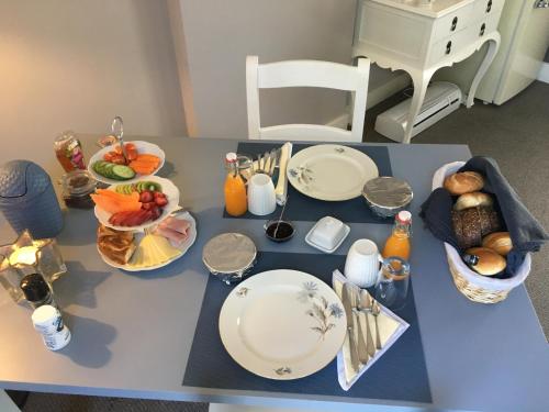 uma mesa com pratos e tigelas de comida em Guesthouse Thoez em Maastricht