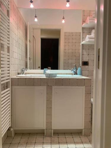a bathroom with two sinks and a large mirror at Casa De Pellegrin Bellagio Lake Como in Bellagio