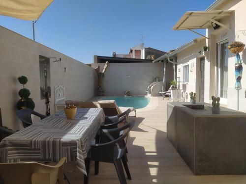 a patio with a table and chairs and a swimming pool at Calymar in Sierra de Yeguas