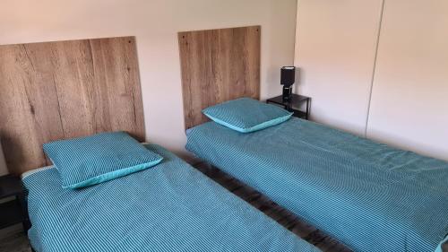 dwa łóżka w pokoju z niebieską pościelą w obiekcie Maison familiale avec jardin clos et barbecue w mieście Le Puy-en-Velay