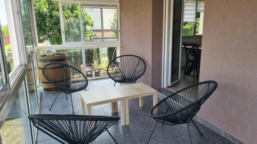 eine Veranda mit Stühlen und einem Tisch auf dem Balkon in der Unterkunft Maison familiale avec jardin clos et barbecue in Le Puy en Velay