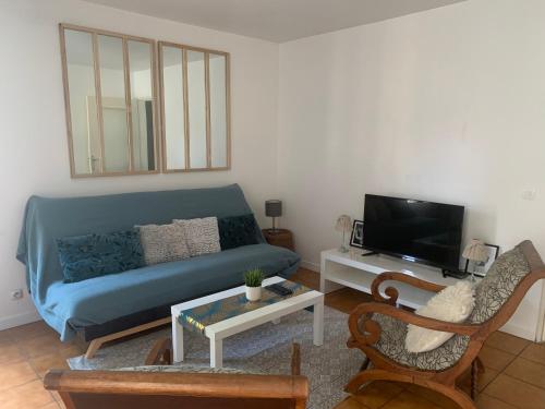 un soggiorno con divano blu e TV di Beau T2 clim terrasse idéalement situé ad Aix en Provence