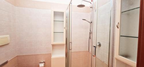 een douche met een glazen deur in de badkamer bij Ancora Apartment in Quartu SantʼElena