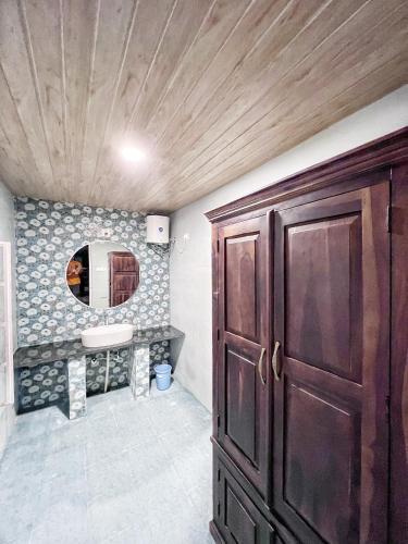 a bathroom with a wooden door and a mirror at The Riverside Estate - 3Bedroom Private Pool Villa in Udaipur in Udaipur