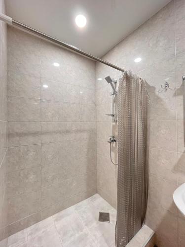 La salle de bains est pourvue d'une douche et d'un lavabo. dans l'établissement Vera City Center Apartment, à Tbilissi