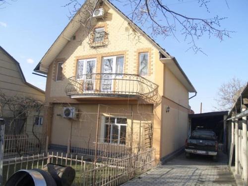 een huis met een balkon en een truck die ervoor geparkeerd staat bij Дом для большой и дружной семьи in Bisjkek