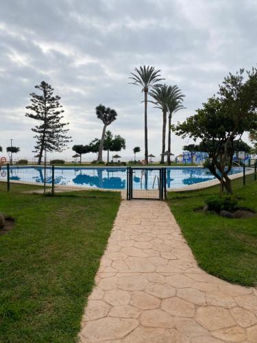 un portail dans un parc avec une piscine dans l'établissement Carré D OR au santa Clara torremolinos, à Torremolinos