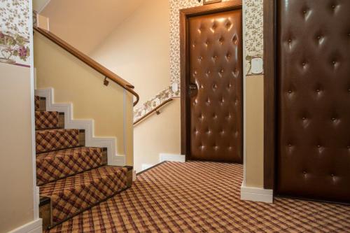 a hallway with a brown door and stairs at Pousada Jardon Campos do Jordão - Exclusiva para Adultos in Campos do Jordão