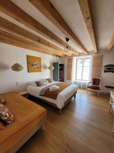 sypialnia z 2 łóżkami w pokoju z drewnianą podłogą w obiekcie Bulle de campagne à Saint Benoit la Forêt w mieście Saint-Benoît-la-Forêt