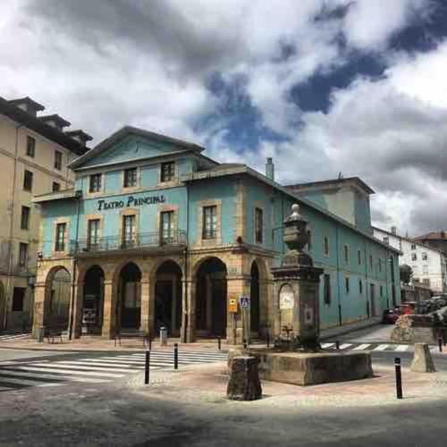 a large blue building with a fountain in front of it at Banksy Love in Reinosa