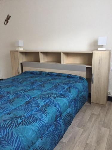 - un lit avec une couette bleue dans l'établissement Bottega, à Petreto-Bicchisano