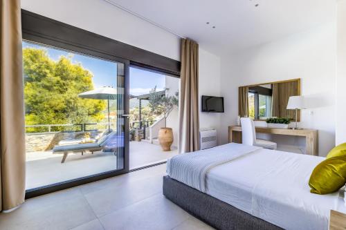 a bedroom with a bed and a view of a patio at Villa Politimi Luxury Retreat in Skopelos Town