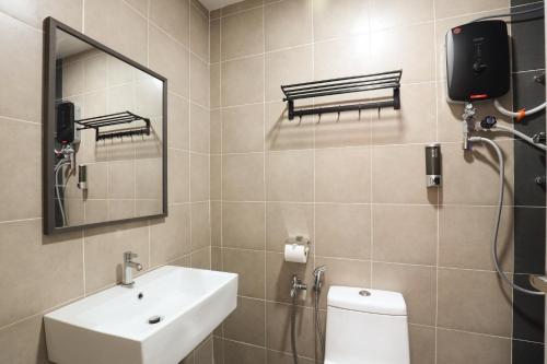 a bathroom with a sink and a toilet and a mirror at Lovely 3-bedroom with Pool - Puchong for 6 Pax in Puchong