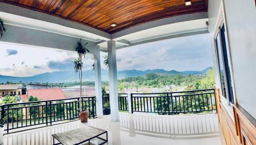 a balcony with a view of the mountains at Mama's Family Guesthouse in Kampot