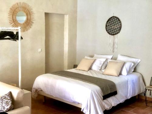 a bedroom with a bed with white sheets and pillows at Domaine Plan des Devens in Roussillon