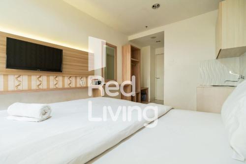 1 dormitorio con 1 cama blanca y TV de pantalla plana en RedLiving Apartemen Sentul Tower - Skyland en Bogor