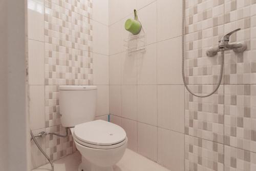 a white bathroom with a toilet and a shower at Koolkost near Stikes Cirebon in Cirebon