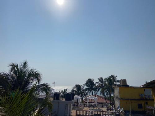 a view of a beach with palm trees and the ocean at Ocean Way Guest House in Baga
