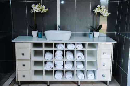a bathroom vanity with a sink and towels at La mbeu concierge in Thohoyandou