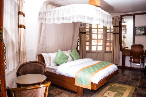a bedroom with a bed with a canopy at Happy Rhino Lodge in Arusha