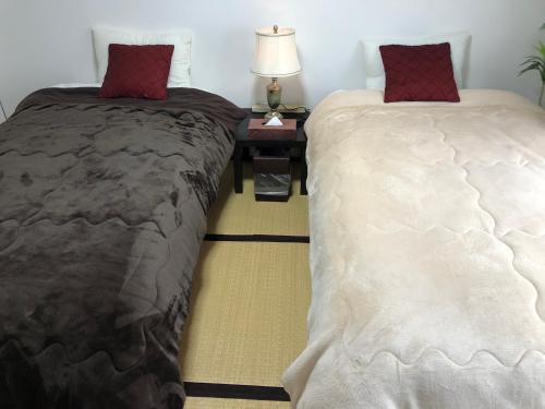 two beds sitting next to each other in a room at Cool-Residence OTARU in Otaru