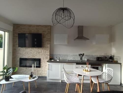 - une cuisine avec deux tables et des chaises dans une pièce dans l'établissement Évasion avec jacuzzi intérieur, à Rosières-près-Troyes