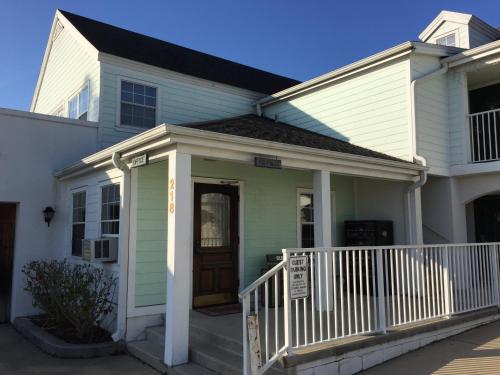 a white house with a porch and a door at Anastasia Inn - Saint Augustine in Saint Augustine