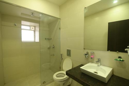 a bathroom with a shower and a toilet and a sink at NK7 AL Newtown in Kolkata