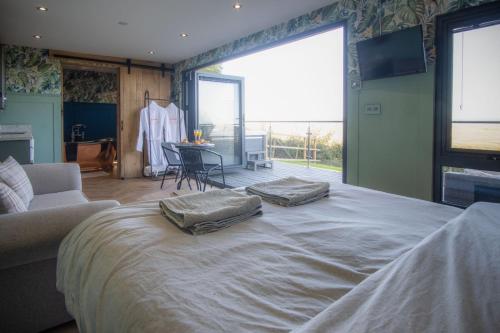 a bedroom with a large bed with two pillows on it at The Langland bay look out in Swansea