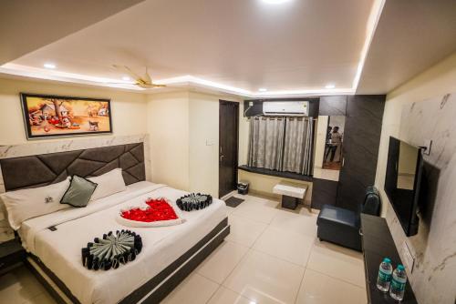 a bedroom with a bed and a television in it at HOTEL PARAMESHWARA luxury awaits in Vijayawāda
