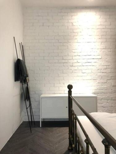 a bedroom with a bed and a white brick wall at 80 Colonie Fraser's Hill 16 Pax in Bukit Fraser