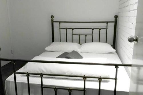 a bed with white sheets and white pillows on it at 80 Colonie Fraser's Hill 16 Pax in Bukit Fraser