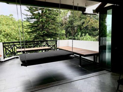 a porch swing with a hammock on a balcony at 80 Colonie Fraser's Hill 16 Pax in Bukit Fraser