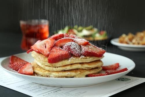 a plate of pancakes with strawberries on a table at Ohio University Inn and Conference Center in Athens