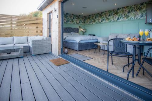 a patio with a bed and a table in a room at The Langland bay look out in Swansea