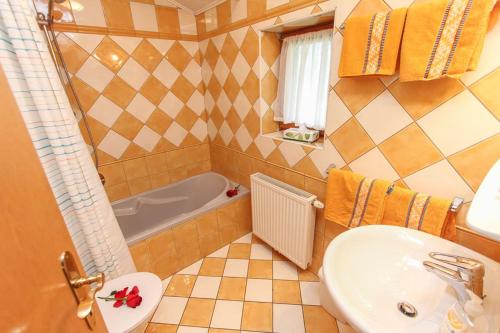 y baño con lavabo y bañera. en Ferienhäuschen Millinghof, en Leogang