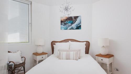 a bedroom with a white bed with white pillows at Riviera - Panoramic Water Views In The Heart Of Nelson Bay in Nelson Bay