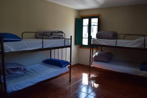 Cette chambre comprend 3 lits superposés et une fenêtre. dans l'établissement Tras do convento, à Samos