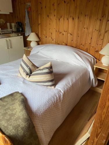 um quarto com uma cama com duas almofadas em Fritidshus i Sandbergen em Stora Frö
