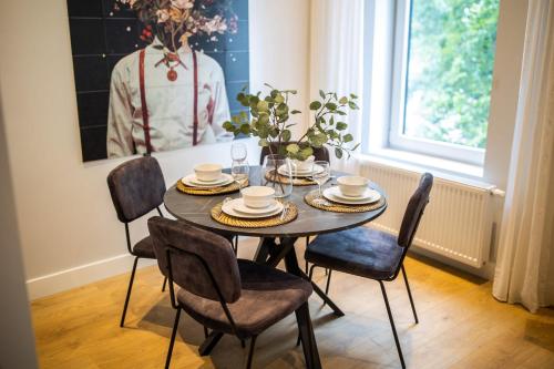 een eetkamer met een tafel en stoelen bij Spacious 2 Bedroom Serviced Apartment 77M2 -VP2B- in Rotterdam