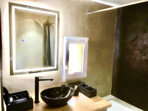 a bathroom with a black sink and a mirror at Domaine Plan des Devens in Roussillon