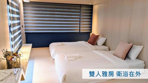 a room with two beds and a window at AiMen Homestay in Huxi