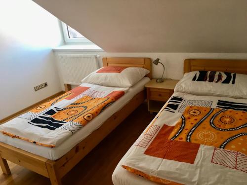 2 nebeneinander sitzende Betten in einem Schlafzimmer in der Unterkunft Sebastian Apartments in Třeboň