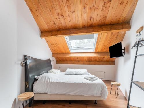 Schlafzimmer mit einem Bett mit Holzdecke in der Unterkunft Pleasant holiday home in Goirle with sauna in Goirle